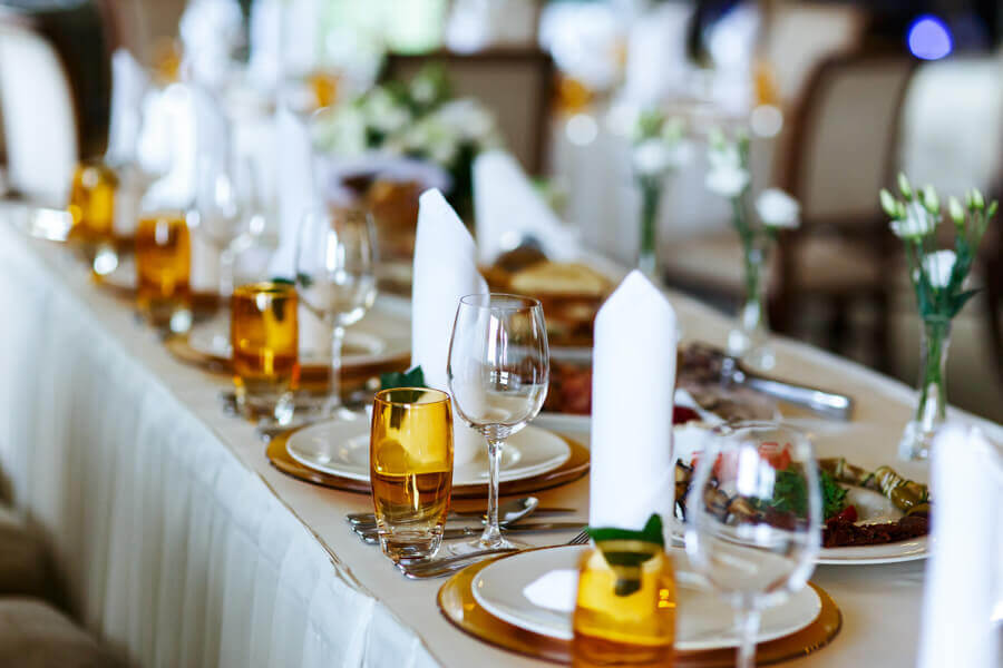 Dining table setup for a function with glasses plates and food